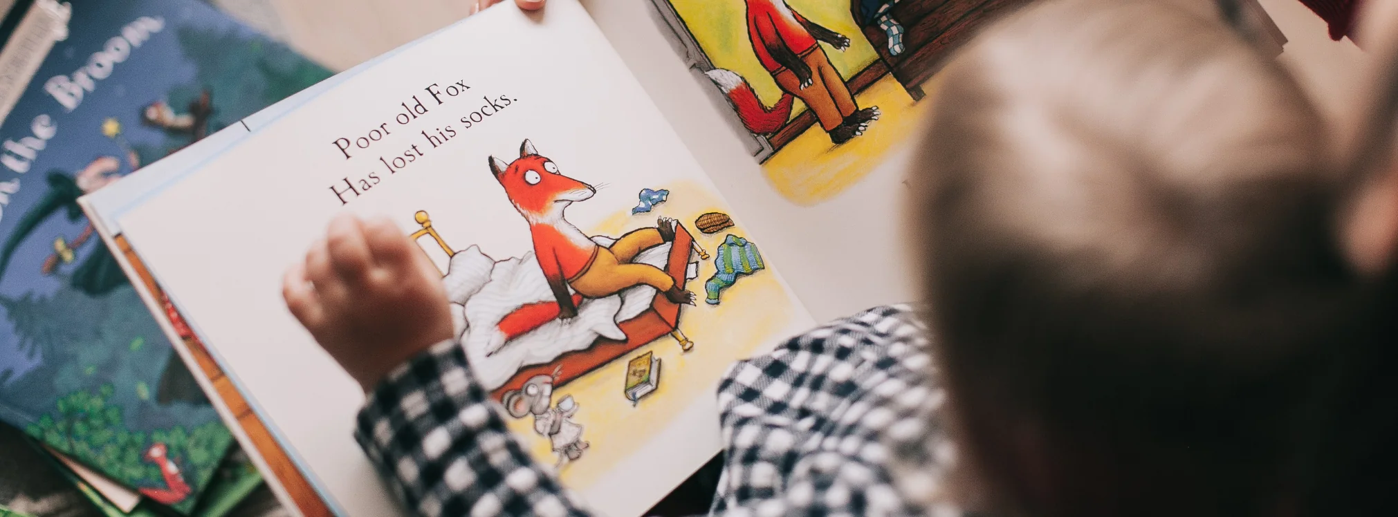 Barn som läser en bilderbok och följer berättelsen med handen